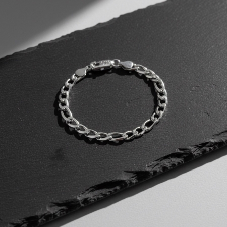 Bracelet chaîne argent sur fond noir texturé