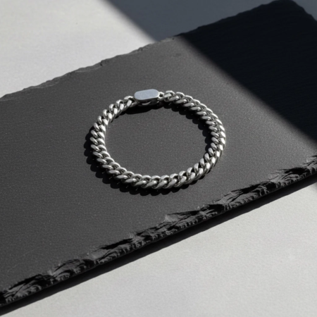 Bracelet chaîne argent sur surface noire texturée