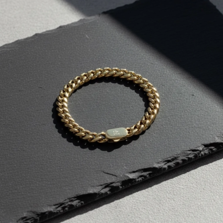 Bracelet chaîne en or sur fond sombre