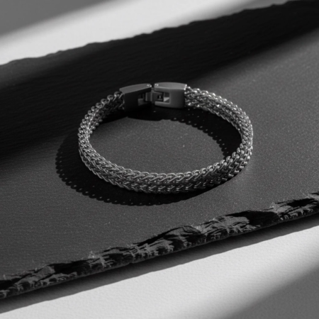 Bracelet tressé en métal sur surface sombre