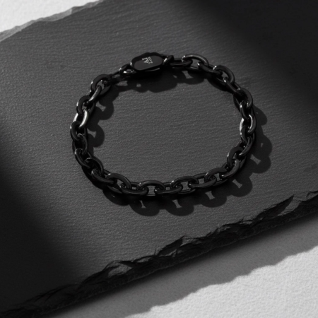 Black chain bracelet on a dark, textured background
