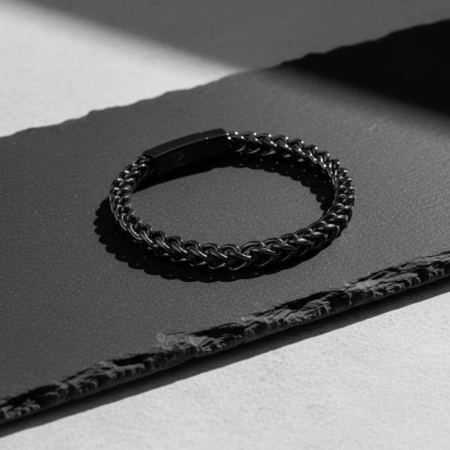 Bracelet chaîne noir en métal sur fond sombre