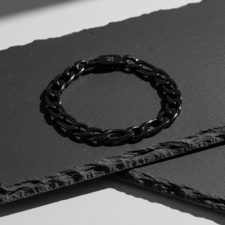 Bracelet chaîne noir sur surface sombre texturée