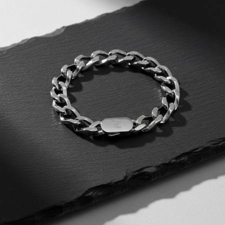 Bracelet chaîne argenté posé sur pierre noire