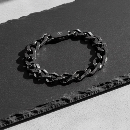 Bracelet chaîne noire en métal sur fond sombre