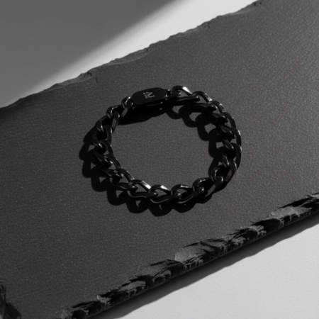 Bracelet chaîne noir sur surface texturée sombre