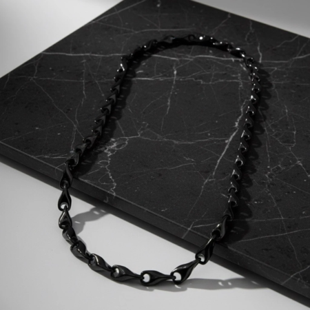 Black chain necklace on dark marble