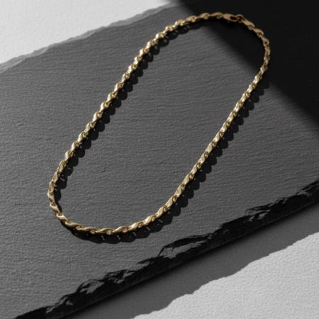 Gold chain necklace on black slate