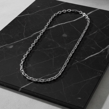 Silver chain necklace on black marble