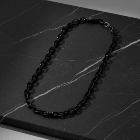 Black chain necklace on a marble surface
