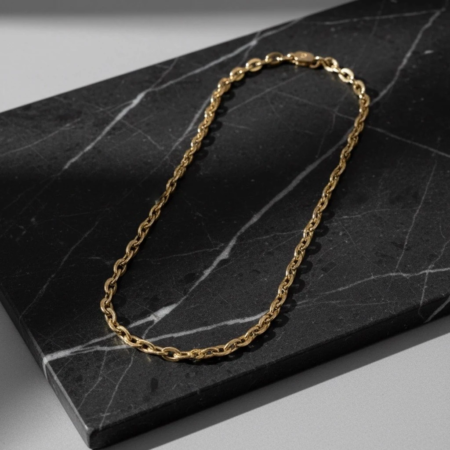 Gold chain necklace on black marble