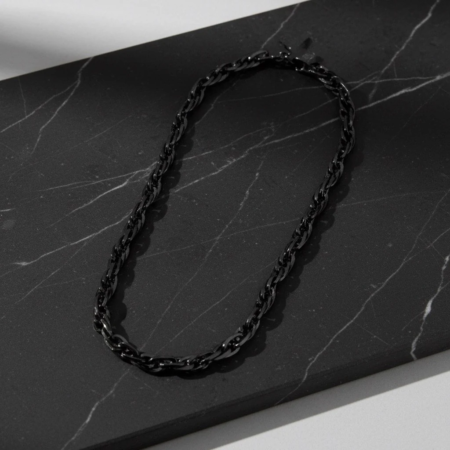 Collier chaîne noir sur surface en marbre