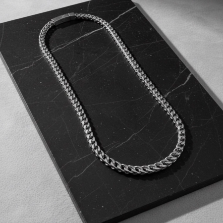 Silver chain necklace on black marble plate
