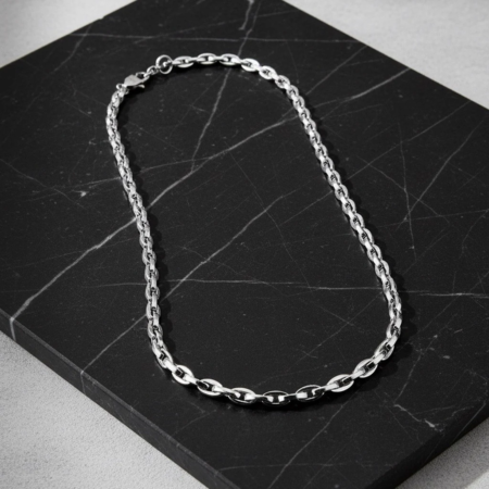 Silver chain necklace on black marble plate