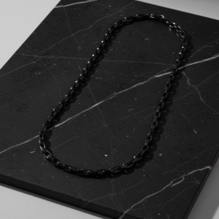 Black chain necklace on black marble
