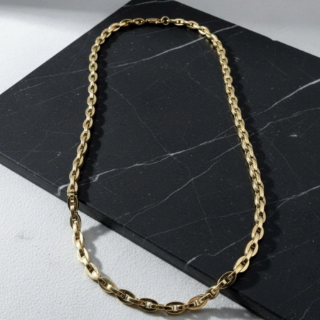 Gold chain necklace on black marble