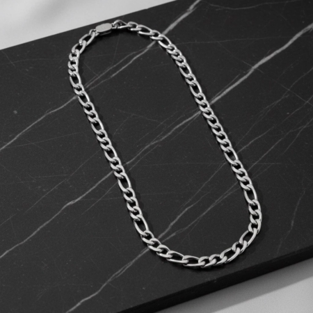 Silver chain necklace on black marble