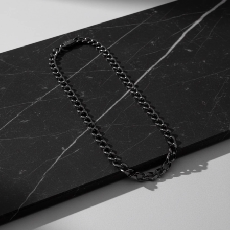 Black chain necklace on marble plate