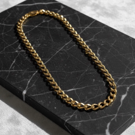 Gold chain necklace on black marble