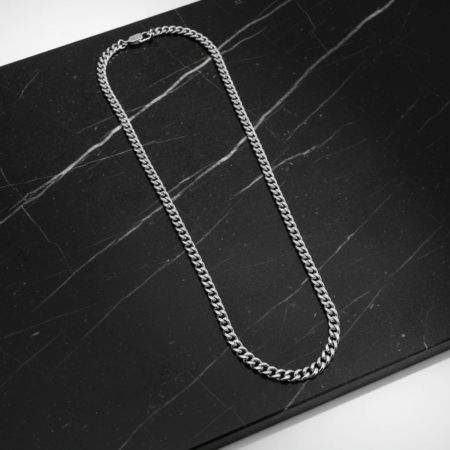 Silver chain necklace on black marble