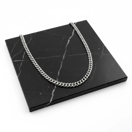 Silver chain necklace on black marble plate