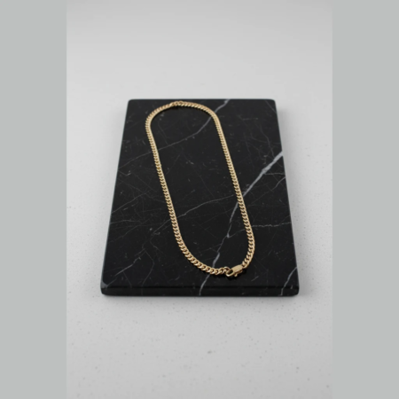 Gold chain on black marble base