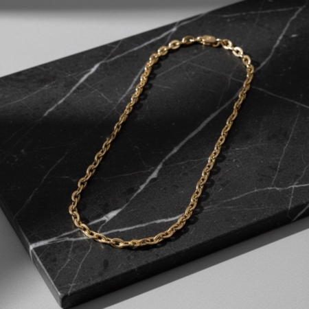 Gold chain necklace on black marble