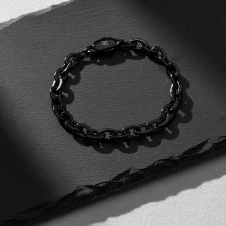 Black chain bracelet on a dark, textured background
