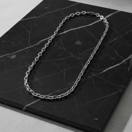 Silver chain necklace on black marble