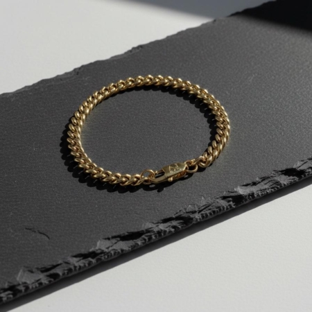 Bracelet chaîne en or sur surface sombre